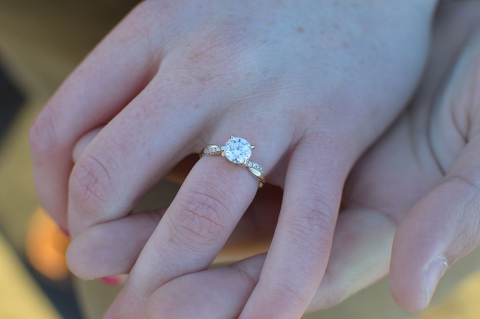 Engagement ring with a raised setting worn on a finger